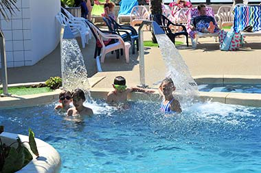 Enfants sous des jets d'eau massant dans la piscine du camping à Saint-Hilaire-de-Riez