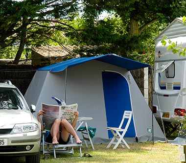 Campeur lisant son journal sur un transat sur son emplacement de camping près de Saint-Jean-de-Monts