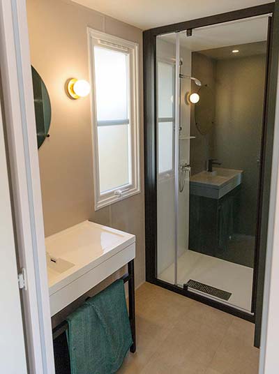 Salle de bain avec douche et lavabo dans un mobil-home au camping à Saint-Hilaire
